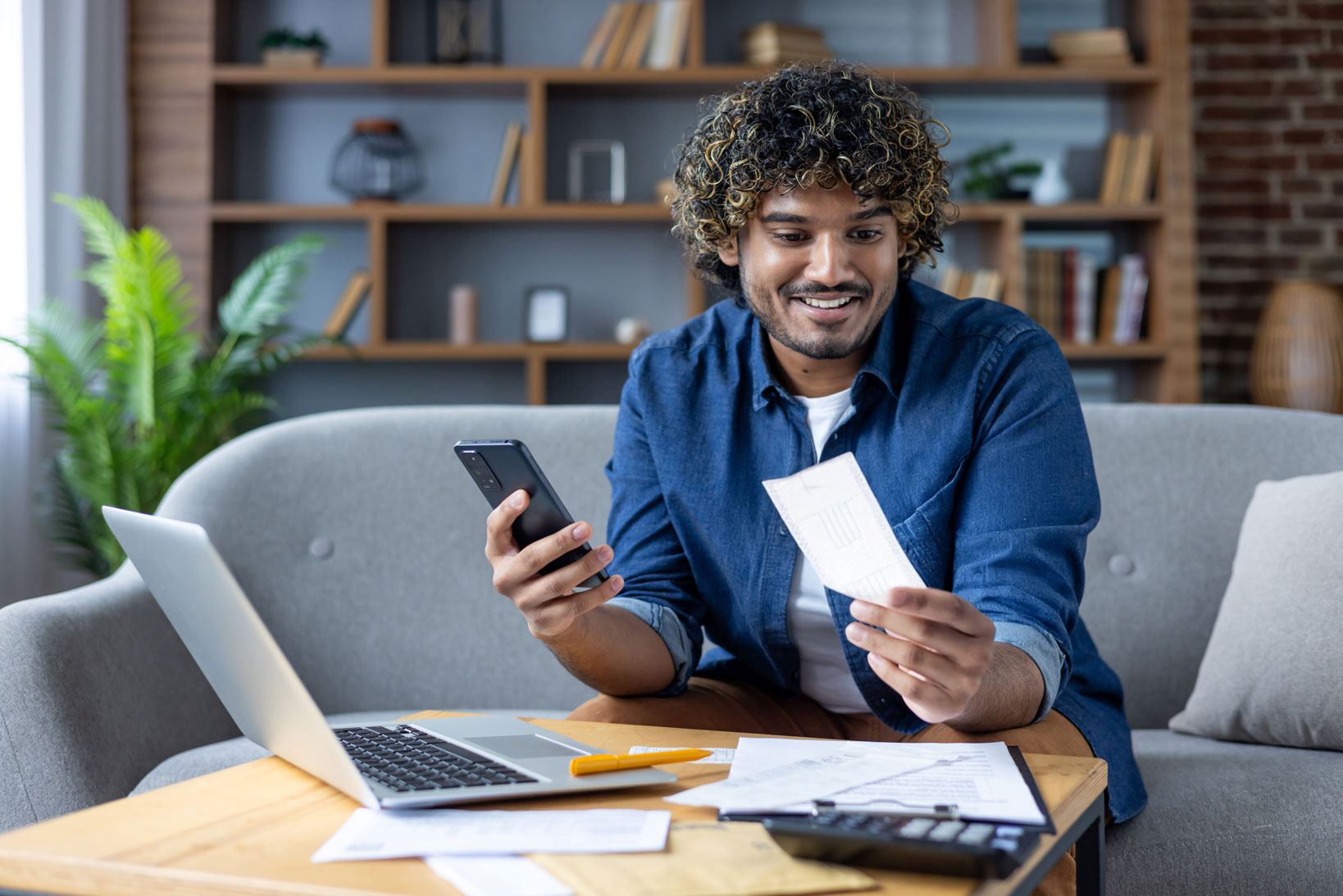 Person managing finances with mobile phone and documents